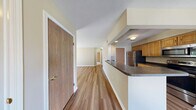 Located at 100 Stillwater Dr S in Horseheads, NY, this one-bedroom, one-bathroom residence offers a thoughtfully organized single-floor layout with a comfortable and functional design throughout. The combined kitchen and living room serves as the heart of the home, featuring warm hardwood-style flooring, neutral beige walls, and a pass-through counter that connects the kitchen to the living area. The kitchen is equipped with oak cabinetry, dark countertops, and stainless steel appliances including a refrigerator, range, microwave, and dishwasher. The living room is bright and open, highlighted by a sliding glass door that fills the space with natural light and provides views of the surrounding greenery. The bedroom offers plush carpeting, a generously sized walk-in closet with wire shelving, and a large window that brings in abundant natural light with pleasant outdoor views. The full bathroom features light tile flooring, a wooden vanity with a sink and mirror, and a clean, functional layout. A dedicated laundry room with a full-sized washer and dryer and overhead wire shelving adds significant convenience. The space is well-suited for those seeking a practical, move-in ready residence in a serene setting.