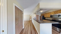 Located at 100 Stillwater Dr S in Horseheads, NY, this one-bedroom, one-bathroom residence offers a thoughtfully organized single-floor layout with a comfortable and functional design throughout. The combined kitchen and living room serves as the heart of the home, featuring warm hardwood-style flooring, neutral beige walls, and a pass-through counter that connects the kitchen to the living area. The kitchen is equipped with oak cabinetry, dark countertops, and stainless steel appliances including a refrigerator, range, microwave, and dishwasher. The living room is bright and open, highlighted by a sliding glass door that fills the space with natural light and provides views of the surrounding greenery. The bedroom offers plush carpeting, a generously sized walk-in closet with wire shelving, and a large window that brings in abundant natural light with pleasant outdoor views. The full bathroom features light tile flooring, a wooden vanity with a sink and mirror, and a clean, functional layout. A dedicated laundry room with a full-sized washer and dryer and overhead wire shelving adds significant convenience. The space is well-suited for those seeking a practical, move-in ready residence in a serene setting.