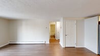 Located at 16 Bailey Ct in Canton, MA, this one-bedroom, one-bathroom residence offers a well-organized single-floor layout designed for comfortable everyday living. Hardwood-style flooring runs throughout, lending a warm and cohesive feel to every room.

The living room is a bright, open space anchored by a sliding glass door that opens to a private balcony with scenic outdoor views. A baseboard heating system lines the walls, and the textured ceiling adds a classic touch to the airy interior.

The kitchen is thoughtfully appointed with white shaker-style cabinetry, clean countertops, and a full suite of stainless steel appliances, including a refrigerator, dishwasher, microwave, and electric range. Light wood-tone flooring complements the crisp white cabinetry for a clean, modern aesthetic.

The spacious primary bedroom comfortably accommodates generous furnishings and features two closets, including a double-door closet offering ample storage. A window brings in natural light, and a wall-unit air conditioner provides personalized climate control.

A hallway connects the main living areas to the bathroom, which is finished in a neutral palette. The overall layout is efficient and functional, making excellent use of the available space throughout.