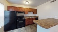 Located at 1100 Barbara Ann Cir. in Winston-Salem, NC, this single-floor home offers a straightforward, functional layout with clean finishes throughout. The entry area welcomes you with rich, dark hardwood-style flooring that extends through the main living spaces, complemented by neutral white walls and a textured ceiling with flush-mount lighting.

The kitchen is a standout feature, outfitted with warm honey-toned wood cabinetry, granite-style countertops, and a full suite of black appliances including a range, refrigerator, and dishwasher. A peninsula counter provides additional prep and dining space, while the adjacent area offers room for a dining setup. A window allows natural light to filter in, and a ceiling vent ensures comfortable climate control.

The bedrooms are carpeted in a warm beige tone, providing a softer feel underfoot, and feature neutral walls that offer a versatile backdrop for any décor. The textured ceilings and flush lighting carry through these rooms, maintaining a consistent aesthetic.

The bathroom includes a full tub and shower combination with clean white surround panels, chrome fixtures, and a built-in towel bar and shelf niche for added convenience.

Overall, this home presents a practical and well-maintained living environment suited for comfortable everyday living in a established Winston-Salem neighborhood.