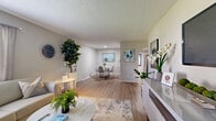 Located at 1900 Post Road in Melbourne, Florida, this single-story, 2-bedroom, 2-bathroom residence offers a thoughtfully designed layout that maximizes functionality and comfort. Light wood-style flooring flows throughout the space, complemented by neutral gray walls and textured ceilings that lend a clean, cohesive aesthetic.

The open-concept living, dining, and kitchen area forms the heart of the home. The living room features a bright window with outdoor views and ample space for comfortable seating. Adjacent to it, the dining area accommodates a round table and connects seamlessly to the kitchen, which is equipped with white shaker-style cabinetry, a white quartz countertop, stainless steel appliances including a dishwasher and refrigerator, a matte black faucet, and a tiled backsplash.

The primary bedroom is a spacious, well-lit retreat with natural light from sheer-curtained windows and a textured ceiling. The second bedroom also features natural light and a sliding-door closet with built-in shelving. Both bathrooms are finished in white with tub-shower combinations, white vanities, and clean tile work.

A hallway with a decorative mirror and recessed lighting connects the private areas, while three closets provide ample storage throughout the home.