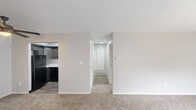 This one-bedroom, one-bathroom residence at 6033 Lake Club Ct in Columbus, Ohio offers a practical and well-organized single-floor layout. The space features two distinct living areas connected by a hallway, providing flexible use of the floor plan. The main living area is bright and open, highlighted by a large sliding glass door with vertical blinds that allow generous natural light to filter in. A ceiling fan adds both function and comfort to the second living area near the entryway, which also features wood-look flooring at the entry transition.

The kitchen has been thoughtfully updated with rich dark wood cabinetry, white quartz countertops, a stainless steel undermount sink with a matte black pull-down faucet, and black appliances including a dishwasher and refrigerator, creating a cohesive, modern aesthetic.

The bedroom is a comfortable size, featuring plush carpeting, a window with exterior views, and a reach-in closet with a sliding door and built-in rod for ample storage. The bathroom is clean and functional, featuring wood-look vinyl flooring, a full bathtub, toilet, and grab bar, finished in a crisp white palette with modern matte black hardware accents. Textured ceilings are present throughout the home.