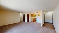 Located at 3330 E Kimberly Rd in Davenport, Iowa, this single-floor home offers four bedrooms and two bathrooms within a practical and functional layout. The open-concept living and kitchen area forms the heart of the home, with plush carpeting in the living space transitioning to hard surface flooring in the kitchen. The kitchen is equipped with warm oak-toned cabinetry, ample counter space, a double sink, a dishwasher, and a full-size refrigerator, all beneath a ceiling fan with light fixture. A textured ceiling runs throughout the home, adding a classic residential character. The spacious living area receives natural light through large sliding glass doors dressed with vertical blinds, offering outdoor views. The four bedrooms are carpeted and well-proportioned, with the primary bedroom providing a comfortable retreat. Dark wood interior doors add a warm contrast to the neutral walls throughout. The two bathrooms are cleanly appointed — one features a standalone walk-in shower with a wood-vanity and sink, while the other includes a full soaking tub with shower. Hallways connect the rooms efficiently, and the overall layout offers a straightforward, livable flow throughout the home.