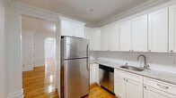 Located at 9201 John F. Kennedy Blvd in North Bergen, NJ, this 2-bedroom, 1-bathroom residence offers a clean, well-maintained layout across a single floor. Warm hardwood flooring runs throughout, complemented by crisp white walls and elegant crown molding that add a classic, polished character to every room.

The kitchen is a standout feature, outfitted with white shaker-style cabinetry extending to the ceiling, granite countertops, and a full suite of stainless steel appliances including a refrigerator, dishwasher, and range. The living room is bright and welcoming, with large black-framed windows that invite natural light and offer views of the surrounding neighborhood.

The spacious primary bedroom provides a generous footprint, while the second bedroom is complemented by its own window with street views. A charming arched doorway connects living areas, adding architectural interest to the layout. A dedicated closet provides practical storage.

The bathroom is neatly finished with large-format gray tile flooring, white wall tiles with a decorative mosaic accent border, and a full tub-shower combination. Throughout the home, the consistent use of white tones and natural wood creates a bright, cohesive, and inviting atmosphere.