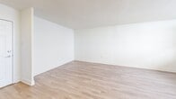Located on the 11th floor at 120 Dundas St E in Mississauga, this two-bedroom, one-bathroom unit offers a clean, modern interior with a bright and airy feel throughout. Light-toned hardwood flooring runs continuously through the living, dining, and bedroom areas, complementing the crisp white walls and textured ceilings.

The open living and dining area provides a comfortable, well-proportioned space filled with natural light from large windows that frame elevated city views. The kitchen features white subway tile backsplashes, modern countertops, and a window that brings in additional natural light and overlooks the surrounding cityscape. Tile flooring in the kitchen adds a practical touch.

Both bedrooms are well-sized, with large windows and baseboard heating units. The primary bedroom includes mirrored sliding closet doors that enhance the sense of space. The second bedroom is equally bright, with a generous layout and an open, versatile feel.

The bathroom is neatly appointed with white subway tile surrounding the soaker tub and shower, warm-toned floor tiles, a wooden vanity with ample storage, and a mirror above the sink. A hallway connects the main living areas to the bedrooms and bathroom, and a balcony provides an outdoor retreat with open views of the city. This unit offers a well-maintained, move-in-ready living space in a convenient Mississauga location.