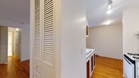 Situated at 5747 N Winthrop Avenue in Chicago's vibrant Edgewater neighborhood, this single-floor unit offers a clean, functional layout with a warm and inviting atmosphere throughout. Gleaming hardwood floors run continuously across the living areas and bedroom, lending a cohesive sense of warmth to the space.

The open living area is well-proportioned, bathed in natural light from windows fitted with blinds, and features a wall-mounted air conditioning unit and baseboard heating for year-round comfort. A ceiling fan adds to the practicality of the bedroom, which also benefits from a bright window and baseboard heating.

The galley-style kitchen is efficiently designed, featuring white cabinetry with wood-accented upper cabinet doors, a gas range, a full-size refrigerator, and a stainless steel sink set beneath a tiled backsplash. Track lighting illuminates the workspace, while a pass-through opening connects the kitchen to the living area, enhancing the sense of openness. A louvered bi-fold door near the entry provides convenient storage access. The layout is practical and well-organized, making this a comfortable Chicago residence in a well-established urban setting.