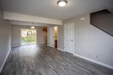 Located at 1175 Willow Run Dr in Abingdon, Virginia, this two-story home offers a functional and well-organized layout across both levels. The main floor features light-toned luxury vinyl plank flooring that extends through the open living area and into the galley-style kitchen. The kitchen is equipped with warm honey-toned wood cabinetry, white countertops, a stainless steel double-basin sink, and a white electric range, with a window providing natural light. A convenient half bathroom is also located on the main level, accessible directly from the living area. A carpeted staircase with white painted railings connects the main floor to the upper level. Upstairs, the bedrooms are finished with plush wall-to-wall carpeting and textured ceilings. Each bedroom offers generous proportions, and select rooms include windows that allow natural light and exterior views. One bedroom features a walk-in closet. The upper-level full bathroom includes a tub/shower combination, a wood-cabinet vanity with a white countertop, and tile-style flooring. Throughout the home, neutral wall tones and clean white trim create a cohesive, move-in-ready aesthetic suited for comfortable everyday living.