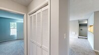 Located at 3803 Cotswold Ave in Greensboro, NC, this single-floor, 2-bedroom, 2-bathroom residence offers a thoughtfully designed layout with comfortable living spaces throughout. The open living room serves as the heart of the home, highlighted by a classic fireplace with a clean white mantel, a ceiling fan with light fixture, and a sliding glass door that opens to an outdoor deck, filling the space with natural light. Plush carpet flooring extends throughout the living areas and bedrooms, complementing the neutral gray walls and textured ceilings. The galley-style kitchen features white shaker cabinets, granite countertops, light wood-look luxury vinyl plank flooring, and black appliances, including a refrigerator and electric range. A louvered pantry door adds convenient storage. The primary bedroom is a comfortable retreat with a walk-in closet with built-in shelving and a window with outdoor views. The secondary bedroom also benefits from natural light through two windows. Both bathrooms offer tub-shower combinations with clean, white surrounds. A dedicated closet provides additional storage, rounding out this well-organized and functional home.