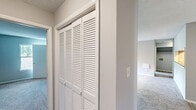 Located at 3803 Cotswold Ave in Greensboro, NC, this single-floor, 2-bedroom, 2-bathroom residence offers a thoughtfully designed layout with comfortable living spaces throughout. The open living room serves as the heart of the home, highlighted by a classic fireplace with a clean white mantel, a ceiling fan with light fixture, and a sliding glass door that opens to an outdoor deck, filling the space with natural light. Plush carpet flooring extends throughout the living areas and bedrooms, complementing the neutral gray walls and textured ceilings. The galley-style kitchen features white shaker cabinets, granite countertops, light wood-look luxury vinyl plank flooring, and black appliances, including a refrigerator and electric range. A louvered pantry door adds convenient storage. The primary bedroom is a comfortable retreat with a walk-in closet with built-in shelving and a window with outdoor views. The secondary bedroom also benefits from natural light through two windows. Both bathrooms offer tub-shower combinations with clean, white surrounds. A dedicated closet provides additional storage, rounding out this well-organized and functional home.