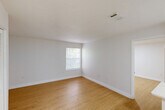 Located at 1220 NW 12th St in Gainesville, FL, this efficient one-bedroom, one-bathroom unit offers a thoughtfully designed layout that maximizes every square foot. The space features light wood-look flooring and crisp white walls throughout, creating a clean, bright atmosphere enhanced by flush-mount ceiling lighting.

The kitchen is outfitted with white shaker-style cabinetry, light quartz countertops, a stainless steel refrigerator, a stainless steel dishwasher, and a black-finish sink faucet — a modern combination that balances style and functionality. The open layout allows the kitchen to flow naturally into the living area, which also features a closet for convenient storage.

The bedroom is a well-proportioned room with a window overlooking lush greenery, allowing natural light and outdoor views to enhance the space. The same warm wood-look flooring continues here, maintaining a cohesive look throughout.

The bathroom features a full tub-shower combination with white tile surround, complemented by black hardware accents. The unit also includes a dedicated closet off the main living area, adding practical storage. The overall design is clean, modern, and move-in ready, making it a functional and attractive option in the Gainesville area.