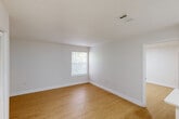 Located at 1220 NW 12th St in Gainesville, FL, this efficient one-bedroom, one-bathroom unit offers a thoughtfully designed layout that maximizes every square foot. The space features light wood-look flooring and crisp white walls throughout, creating a clean, bright atmosphere enhanced by flush-mount ceiling lighting.

The kitchen is outfitted with white shaker-style cabinetry, light quartz countertops, a stainless steel refrigerator, a stainless steel dishwasher, and a black-finish sink faucet — a modern combination that balances style and functionality. The open layout allows the kitchen to flow naturally into the living area, which also features a closet for convenient storage.

The bedroom is a well-proportioned room with a window overlooking lush greenery, allowing natural light and outdoor views to enhance the space. The same warm wood-look flooring continues here, maintaining a cohesive look throughout.

The bathroom features a full tub-shower combination with white tile surround, complemented by black hardware accents. The unit also includes a dedicated closet off the main living area, adding practical storage. The overall design is clean, modern, and move-in ready, making it a functional and attractive option in the Gainesville area.
