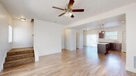 Located at 1400 Morning Vista Rd in Lehi, Utah, this two-story home offers a thoughtfully designed layout spread across two floors. The main level features an open-concept living area with light hardwood-style flooring, a ceiling fan, and large windows that invite abundant natural light. A staircase with carpeted treads connects both levels seamlessly. The kitchen is a standout feature, showcasing rich dark wood cabinetry, light quartz countertops, a central island with pendant lighting, and stainless steel appliances including a refrigerator and gas range. A convenient half bathroom is also located on the main floor. Upstairs, two carpeted bedrooms provide comfortable retreats, each featuring windows with outdoor views and wainscoting-style wall detailing. The spacious primary bedroom includes a well-organized walk-in closet with built-in shelving and hanging rods. Two full bathrooms on the upper level are finished with matching dark wood vanities, quartz countertops, and tub-shower combinations. Throughout the home, a consistent neutral color palette and cohesive finishes create a clean, modern aesthetic. Two dedicated closets and ample storage add to the home's practical appeal.