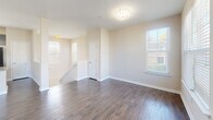 Located at 8816 Aspinwall Dr in Charlotte, NC, this two-story home offers 2 bedrooms and 2 bathrooms thoughtfully distributed across two floors. The ground level houses an attached garage with an automatic opener, polished concrete flooring, and direct interior access to the main living area.

The upper floor serves as the heart of the home, anchored by an open-concept kitchen and living room. The kitchen is outfitted with dark espresso shaker cabinets, granite countertops, a center island with a double sink, pendant lighting, and black stainless appliances, all set atop rich hardwood-style flooring that flows throughout the main living spaces.

Both bedrooms are carpeted for comfort and feature windows that invite natural light and outdoor views. The generously sized primary bedroom includes a walk-in closet with wire shelving for ample storage. The primary bathroom features a dark vanity cabinet with granite countertops, a framed mirror, and hardwood-style flooring. A second full bathroom and additional closet serve the remaining bedroom.

Neutral warm tones on the walls, clean white trim, and an abundance of windows with blinds give the entire home a bright, move-in-ready ambiance. A staircase connects the two floors, completing this well-organized and practical layout.