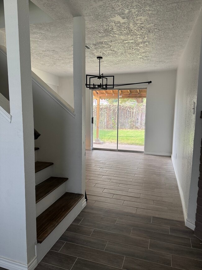 Open entryway highlighting continuous flooring, natural light, and access to upper levels. - 10038 Spring Place Dr