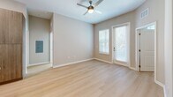 Located at 1314 SW 61st Terrace in Gainesville, FL, this thoughtfully designed 2-bedroom, 3-bathroom single-story home offers a clean, modern aesthetic with quality finishes throughout. Light wood flooring flows seamlessly across the entire living space, creating a warm and cohesive atmosphere.

The open-concept kitchen is a standout feature, showcasing a large center island with a built-in sink and pendant lighting, stainless steel appliances including a refrigerator, electric range, and microwave, and a sophisticated two-tone cabinet design pairing white upper cabinets with warm wood-toned lower cabinets. A subtle tile backsplash completes the contemporary look.

The living area is bright and airy, with natural light filtering through large windows and a glass-panel door, complemented by a ceiling fan overhead. The spacious primary bedroom features vaulted ceilings, adding a sense of openness, along with a dedicated walk-in closet equipped with multi-tier wire shelving for generous storage. A second bedroom also benefits from natural light and a ceiling fan.

The bathrooms are finished to a high standard, with one featuring a frameless glass walk-in shower with large-format tile walls and a mosaic tile floor, paired with a sleek wood-toned vanity and white countertop. Two walk-in closets provide ample storage throughout the home.