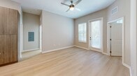 Located at 1314 SW 61st Terrace in Gainesville, FL, this thoughtfully designed 2-bedroom, 3-bathroom single-story home offers a clean, modern aesthetic with quality finishes throughout. Light wood flooring flows seamlessly across the entire living space, creating a warm and cohesive atmosphere.

The open-concept kitchen is a standout feature, showcasing a large center island with a built-in sink and pendant lighting, stainless steel appliances including a refrigerator, electric range, and microwave, and a sophisticated two-tone cabinet design pairing white upper cabinets with warm wood-toned lower cabinets. A subtle tile backsplash completes the contemporary look.

The living area is bright and airy, with natural light filtering through large windows and a glass-panel door, complemented by a ceiling fan overhead. The spacious primary bedroom features vaulted ceilings, adding a sense of openness, along with a dedicated walk-in closet equipped with multi-tier wire shelving for generous storage. A second bedroom also benefits from natural light and a ceiling fan.

The bathrooms are finished to a high standard, with one featuring a frameless glass walk-in shower with large-format tile walls and a mosaic tile floor, paired with a sleek wood-toned vanity and white countertop. Two walk-in closets provide ample storage throughout the home.