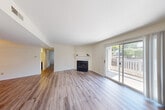 Located at 1101 Olive Lake Dr in Olivette, MO, this single-floor, three-bedroom, two-bathroom home offers a well-organized layout with a practical mix of comfort and functionality. The living room serves as the centerpiece of the home, showcasing light hardwood-style flooring, a classic fireplace with a white mantel, and large sliding glass doors that open to a private outdoor deck, filling the space with natural light and offering pleasant outdoor views. The kitchen is designed in a galley style, featuring dark cabinetry, light countertops, hardwood-style flooring, and black appliances including a stove and refrigerator. A pass-through window connects the kitchen to the adjacent space, enhancing the open feel. The three bedrooms are carpeted in a neutral tone, offering a warm and comfortable atmosphere. The primary bedroom includes mirrored sliding closet doors that reflect light throughout the room. The remaining bedrooms are bright and versatile. The two bathrooms are clean and simply appointed, with one featuring a full tub-shower combination with chrome fixtures and wood-style flooring. Throughout the home, neutral walls and consistent flooring choices create a cohesive, move-in ready environment.