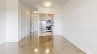 Located at 4750 Bathurst Street in Toronto's North York neighbourhood, this studio unit offers a well-organized single-floor layout that efficiently combines living and kitchen functions within a compact footprint. The open-concept living area is anchored by large, floor-to-ceiling windows that flood the space with natural light and frame pleasant views of the tree-lined street below. Polished parquet flooring runs throughout, adding warmth and a classic character to the bright, white-walled interior. A baseboard heating system runs along the windowed wall, ensuring year-round comfort.

The kitchen is neatly tucked into a defined nook, equipped with light-toned cabinetry, a stainless steel refrigerator, built-in microwave, and electric stove, providing all essential cooking amenities in a space-conscious design. A hallway connects the living area to the full bathroom, which features clean white subway tile surrounding a soaking bathtub and shower combination with chrome fixtures. The vanity area includes a sink and mirror, maintaining a crisp, modern aesthetic throughout. The unit's clean, neutral palette and efficient layout make it a practical and functional living space in a well-established Toronto neighbourhood.