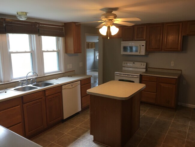 Kitchen with island, includes dishwasher, stove, microwave, and refrigerator - 103 E 6th Street