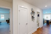 Located at 95 Newport Ave in East Providence, Rhode Island, this well-designed two-bedroom, two-bathroom residence offers a thoughtfully laid-out single-floor plan with modern finishes throughout. The open-concept kitchen and living area serves as the heart of the home, featuring rich hardwood flooring, dark navy cabinetry, stainless steel appliances, recessed lighting, and a central island with a clean white countertop — ideal for both cooking and casual dining. The living room is generously sized, filled with natural light from multiple large windows, and includes access to an exterior door. The spacious primary bedroom is carpeted, bright, and accommodating, with a large window and ample room for furnishings. A dedicated closet provides practical storage. The second bedroom is equally well-proportioned, also featuring plush carpeting and wall space suitable for various configurations. Both bathrooms are clean and modern; one features classic black-and-white mosaic tile flooring, a dark vanity with white countertop, and a shower-tub combination. The hallway connecting the rooms is clean and bright, accented with tasteful wall décor. Two closets add to the home's overall storage capacity, completing this functional and stylish residence.