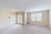 Located at 11 Ledgewood Rd in Groton, Connecticut, this one-bedroom, one-bathroom residence offers a well-organized single-floor layout designed for comfortable everyday living. The open-concept main area seamlessly combines the living room, dining room, and kitchen, creating a bright and versatile space. The living area features soft wall-to-wall carpeting, crown molding, and abundant natural light courtesy of a large picture window and classic French doors that lead out to a private balcony. The kitchen is well-appointed with white shaker cabinetry, granite countertops, a breakfast bar peninsula, and a full suite of stainless steel appliances including a gas range, microwave, dishwasher, and refrigerator, all set over hardwood-style flooring. The bathroom features an extended dual-sink vanity with a large mirror and track lighting, paired with hardwood-style flooring for a clean, modern look. The bedroom is generously proportioned, finished with plush carpeting, crown molding, a bright corner window, and access to a spacious walk-in closet. Additional highlights include two closets, a dedicated laundry area, and a utility room, rounding out a highly functional and complete living space.
