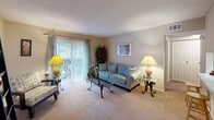 Located at 1630 Delane Ave in the desirable 28211 zip code of Charlotte, NC, this single-floor residence offers a thoughtfully designed layout with a warm, comfortable ambiance throughout. The living room serves as the heart of the home, featuring plush carpeting, neutral warm-toned walls, and a textured ceiling. Large sliding glass doors flood the space with natural light and provide access to an outdoor area, while a convenient pass-through window connects the living area to the kitchen, enhancing the open feel. The kitchen is efficiently laid out with white appliances and cabinetry, complemented by a small dining area nearby, ideal for casual meals. The bedroom is generously sized, also finished with soft carpeting and a textured ceiling, and benefits from natural light through a window with blinds. A walk-in closet provides ample storage space. The full bathroom is finished with tile flooring and includes a tub/shower combination, vanity with sink, and toilet, offering functional everyday convenience. Throughout the residence, the cohesive neutral color palette and consistent flooring choices create a unified, easy-to-personalize living environment in a well-established Charlotte neighborhood.