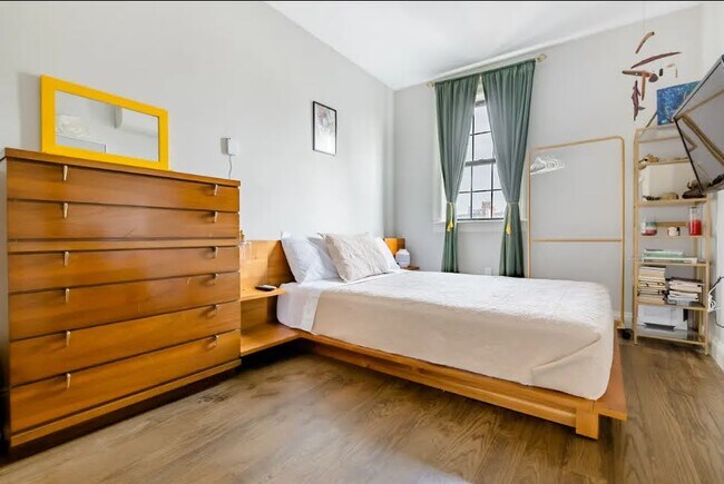 Dormitorio principal con cama king size y baño privado, amueblado con muebles modernos de mediados de siglo en madera maciza. - 504 Maple St