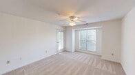 Located at Hamiltons Harbor Drive in Lake Wylie, South Carolina, this one-bedroom, one-bathroom unit offers a well-organized single-floor layout designed for comfortable everyday living. The living room is bright and welcoming, featuring plush wall-to-wall carpeting, a ceiling fan with light fixture, and a large window that fills the space with natural light and frames pleasant views of the surrounding mature trees. The room flows openly toward the kitchen area, creating a connected and functional common space. The kitchen is efficiently laid out in a U-shape, featuring white cabinetry with gold hardware, light countertops, wood-look flooring, and white appliances including a refrigerator, electric range, and dishwasher. The bedroom is a comfortable, well-proportioned retreat with soft carpeting, a ceiling fan, and a window with outdoor views, complemented by access to a dedicated closet. The full bathroom is clean and practical, finished with wood-look flooring, a tub-shower combination, and a vanity with storage. A private balcony accessible from the unit offers a peaceful outdoor setting surrounded by lush greenery, adding a tranquil natural element to this tidy and functional Lake Wylie residence.