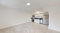 Located at 147 NW 59th St in Miami's dynamic Little Haiti neighborhood, this 4-bedroom, 2-bathroom unit offers a thoughtfully designed single-floor layout ideal for comfortable urban living. The interior is finished with light-toned large-format tile flooring throughout, complemented by crisp white walls that create a bright, airy atmosphere across all rooms.

The kitchen is well-appointed with white shaker-style cabinetry, dark stone countertops, and a full suite of stainless steel appliances including a refrigerator, dishwasher, range, and over-the-range microwave. It flows directly into the open living area, making the combined kitchen and living room a functional hub of the home.

The four bedrooms are bright and cleanly finished, with multiple rooms featuring windows that bring in natural light and views of surrounding greenery. The primary bedroom offers a comfortable footprint with ample wall space. Additional bedrooms are versatile and well-proportioned.

Both bathrooms feature striking walk-in showers tiled floor-to-ceiling in large-format charcoal slate-style tile, contrasted by classic white hexagonal mosaic shower floors and chrome fixtures — a bold, contemporary design choice. A hallway connects the living spaces to the bedrooms and bathrooms, and the unit also includes a dedicated storage or utility closet. The overall aesthetic is clean, modern, and move-in ready.