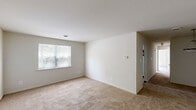 Located at 26 Cheswold Blvd in Newark, Delaware, this single-floor, three-bedroom, one-bathroom home offers a straightforward and functional layout. The interior is finished with neutral, cream-toned walls throughout, creating a clean and cohesive aesthetic across all rooms.

The spacious primary bedroom features plush wall-to-wall carpeting, a window with blinds that allows natural light to filter in, and direct access to a dedicated closet complete with a full-width hanging rod for ample storage. The two additional bedrooms are similarly carpeted and bright, each featuring windows with blinds — one room benefits from dual windows that bring in generous natural light.

The kitchen is equipped with dark wood cabinetry offering substantial upper and lower storage, white countertops, a single-basin stainless steel sink, and white appliances including a stovetop range and dishwasher. A window above the sink adds natural light to the workspace.

The full bathroom features tile flooring, a vanity with white cabinetry, a tiled shower/tub area, and a toilet — providing all essential amenities in a compact, functional layout.

Throughout the home, the carpeted living areas, neutral palette, and consistent window treatments contribute to a simple, move-in-ready atmosphere suited for comfortable everyday living.