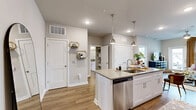 This well-appointed one-bedroom, one-bathroom residence in Charlotte, NC offers a thoughtfully designed single-level layout across approximately 710 square feet. The open-concept living area seamlessly connects the kitchen, dining, and living spaces, creating an efficient and inviting floor plan. The kitchen is outfitted with white shaker cabinetry, quartz countertops, stainless steel appliances including a refrigerator, range, microwave, and dishwasher, and a peninsula island with pendant lighting that doubles as a breakfast bar. Wood-look plank flooring flows throughout the home, complementing the neutral gray tones on the walls. The living room benefits from large windows that invite natural light and provide outdoor views, and is equipped with a ceiling fan. The primary bedroom offers a comfortable retreat with a ceiling fan, large window, and direct access to the bathroom. The full bathroom features a dual-sink vanity with a wide mirror and white cabinetry. Two closets provide generous storage, including a walk-in closet with wire shelving. A dedicated laundry area and utility room add further convenience to this functional and modern home.