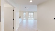 Located at 220 Quimby St NE in Grand Rapids, Michigan, this single-floor unit offers a clean, modern aesthetic defined by bright white walls, light hardwood-style flooring, and recessed lighting throughout. The open-concept living and dining area is anchored by expansive floor-to-ceiling windows that flood the space with natural light and provide elevated views of the surrounding Grand Rapids neighborhood. The kitchen is well-appointed with white shaker-style cabinetry featuring matte black hardware, white quartz countertops, a subway tile backsplash, and a full suite of stainless steel appliances including a range, over-the-range microwave, and refrigerator. A peninsula with a black-accented faucet adds additional prep and dining space. The primary bathroom features a dual-sink vanity with a white quartz countertop, shaker-style cabinetry, matte black fixtures, and large mirrored medicine cabinets with integrated lighting. A secondary bathroom includes a walk-in shower with matte black hardware. A spacious walk-in closet with wire shelving provides generous storage. Additional bedrooms are bright and well-proportioned, benefiting from large windows with scenic outdoor views. The consistent use of matte black accents, neutral tones, and quality materials gives the space a cohesive, contemporary character throughout.