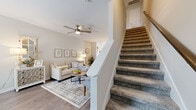 Located at 2875 Trough Springs Road in Clarksville, TN, this two-story home offers a well-designed layout spread across two floors. The main level serves as the heart of the home, where an open-concept living, dining, and kitchen area creates a bright and welcoming atmosphere. The living room features wood-look flooring, a ceiling fan, and a neutral color palette that lends a clean, airy feel. The kitchen is outfitted with gray shaker-style cabinetry, granite-look countertops, a classic subway tile backsplash, and a full suite of stainless steel appliances, including a gas range, built-in microwave, and side-by-side refrigerator. A dedicated dining area with natural light and a closet for additional storage completes the main floor. Carpeted stairs with white painted railings lead to the upper level, where the generously sized primary bedroom awaits, complete with plush carpet, a ceiling fan, and its own dedicated closet. Two full bathrooms — one on each floor — provide added convenience, with clean, white finishes and a tub/shower combination. The overall design is cohesive and move-in ready, blending functional living spaces with modern, neutral finishes throughout.