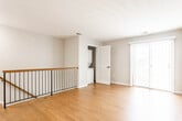 Located at 223 Calderone St in South Plainfield, NJ, this single-floor residence offers a clean, modern aesthetic throughout. The open living area serves as the heart of the unit, featuring warm hardwood flooring, neutral gray walls, and abundant natural light drawn in through a front entry window and a sliding glass door fitted with vertical blinds — providing both outdoor access and a view of the surrounding greenery.

The kitchen is a standout feature, finished with sleek white cabinetry, bold marble-patterned countertops and matching backsplash, and large-format marble-look tile flooring. Stainless steel appliances, including a gas range, over-the-range microwave, and refrigerator, complete the modern, functional space.

The bedrooms continue the hardwood flooring theme and are filled with natural light from windows with blinds. One bedroom offers a walk-in closet with built-in shelving, providing generous storage. Crisp white six-panel doors with matte black hardware are consistent throughout the unit, reinforcing a cohesive, contemporary design.

The bathroom features large-format travertine-style tile flooring, textured wall tile surrounding a soaking tub with shower, a floating wood-toned vanity with an integrated sink, and a mirrored medicine cabinet — delivering a refined, spa-like feel.