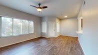 This single-floor residence offers a thoughtfully designed layout with a clean, modern aesthetic throughout. The open living area is finished with durable wood-look plank flooring and features a ceiling fan with integrated lighting. Multiple windows fitted with horizontal blinds allow generous natural light to fill the space while maintaining privacy. A front entry door with a smart lock provides secure access directly into the main living area.

The kitchen is equipped with stainless steel appliances, including a refrigerator, electric range, and over-the-range microwave. Rich dark-toned cabinetry pairs with white countertops to create a functional and visually appealing workspace.

The bedrooms are finished with plush carpeting and feature windows that bring in natural light. Several bedrooms include ceiling fans for added comfort, while neutral-toned walls provide a versatile backdrop throughout.

The bathrooms are appointed with wood-look tile flooring, dark vanity cabinetry, white countertops, and full tub-shower combinations with tiled surrounds. Brushed nickel fixtures and well-lit vanity mirrors complete the clean, contemporary look. The overall design of the residence emphasizes functionality and comfort with a cohesive, neutral color palette.
