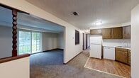 Located at 3686 Big Tree Rd in Hamburg, NY, this single-floor residence offers two bedrooms and one bathroom within a well-organized layout. The open living area features plush carpeting and a sliding glass door that fills the space with natural light and provides views of the surrounding greenery. An arched passageway connects the living room to the rest of the unit, creating a natural flow throughout.

The kitchen is equipped with wood-toned cabinetry, a white refrigerator, and hardwood-style flooring, offering a practical and tidy cooking space. A hallway connects the main living areas to the bedrooms and bathroom, maintaining a clear and efficient floor plan.

The generously sized primary bedroom includes a closet with built-in shelving and carpet flooring, while the second bedroom also features carpet and a window overlooking the yard. Both bedrooms are finished with neutral tones and textured ceilings, contributing to a calm and understated atmosphere.

The full bathroom is outfitted with a tub-shower combination, toilet, and vanity, all set on wood-style vinyl flooring. Throughout the unit, consistent use of neutral walls, dark baseboards, and textured ceilings creates a cohesive and functional living environment.