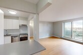 Located at 9 Ellis St E in Windsor, Ontario, this efficiently designed one-bedroom, one-bathroom unit offers a clean, modern aesthetic throughout. The open-concept kitchen and living room form the heart of the space, where light hardwood flooring extends seamlessly underfoot and neutral grey walls create a bright, cohesive atmosphere. The kitchen is equipped with white cabinetry, a grey countertop, a stainless steel sink with a modern faucet, a tiled backsplash, and a stainless steel range, while a breakfast bar provides a convenient transition into the living area. The living room benefits from a large window that invites natural light and offers outdoor views, complemented by a baseboard heating unit along the wall. The bedroom is a comfortable, well-proportioned room featuring hardwood flooring, a window with exterior views, a closet, and a baseboard heater. The bathroom includes a full-size soaker tub finished with clean white tile surround. A hallway connects the rooms, completing the functional layout of this compact yet practical unit.