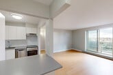 Located at 9 Ellis St E in Windsor, Ontario, this efficiently designed one-bedroom, one-bathroom unit offers a clean, modern aesthetic throughout. The open-concept kitchen and living room form the heart of the space, where light hardwood flooring extends seamlessly underfoot and neutral grey walls create a bright, cohesive atmosphere. The kitchen is equipped with white cabinetry, a grey countertop, a stainless steel sink with a modern faucet, a tiled backsplash, and a stainless steel range, while a breakfast bar provides a convenient transition into the living area. The living room benefits from a large window that invites natural light and offers outdoor views, complemented by a baseboard heating unit along the wall. The bedroom is a comfortable, well-proportioned room featuring hardwood flooring, a window with exterior views, a closet, and a baseboard heater. The bathroom includes a full-size soaker tub finished with clean white tile surround. A hallway connects the rooms, completing the functional layout of this compact yet practical unit.