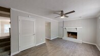 Located at 348 Tall Oaks Dr in Conyers, GA, this two-story home offers 3 bedrooms and 2 bathrooms across two evenly distributed floors. The main level features a welcoming living room with hardwood-style flooring, crown molding, a classic white-painted brick fireplace, and a ceiling fan — creating a warm, functional gathering space. The kitchen is well-appointed with white shaker cabinetry, granite countertops, a white subway tile backsplash, stainless steel appliances including a refrigerator, range, and dishwasher, and light wood-style flooring that flows throughout the lower level. A hallway and staircase connect the two floors seamlessly. Upstairs, three carpeted bedrooms provide comfortable retreats, each equipped with ceiling fans and windows that allow natural light to filter in. The spacious primary bedroom offers ample room for furnishings. The bathrooms are finished with granite-topped white vanities, wood-style tile flooring, and clean white fixtures, with one bathroom featuring a tub-shower combo. Neutral gray tones throughout the home create a cohesive, modern aesthetic. The layout is practical and efficient, making excellent use of the available space across both levels.
