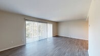 Located at 450 Briar Lane NE in Grand Rapids, Michigan, this single-floor, 3-bedroom, 2-bathroom home offers a well-organized and functional layout. The living room is a standout space, featuring wide-plank wood-look flooring and a large sliding glass door fitted with vertical blinds that floods the room with natural light and offers views of the surrounding greenery. The kitchen is equipped with dark walnut-toned cabinetry, a subway tile backsplash, light stone countertops, and stainless steel appliances including a gas range, built-in microwave, and refrigerator. A hallway connects the main living areas to the private quarters, providing a natural separation between spaces. The three bedrooms feature plush carpeting and windows that bring in natural light, creating a comfortable and restful atmosphere. The primary bedroom is a well-proportioned retreat with a sliding mirrored closet offering built-in shelving and hanging space. The bathrooms include a tub-shower combination with beige tile surround and coordinating tile flooring. Two hallways provide efficient circulation throughout the home, and a dedicated closet adds additional storage. Neutral wall tones and clean finishes give the home a move-in ready feel throughout.