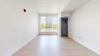 Located at 9998 W Jewell Ave in Lakewood, Colorado, this thoughtfully designed 2-bedroom, 2-bathroom unit offers a clean, modern aesthetic across a well-utilized single floor. Light wood-style flooring runs throughout the space, complementing the crisp white walls and creating a bright, cohesive feel.

The open-concept kitchen and living area serves as the heart of the unit. The kitchen is a standout feature, showcasing two-tone cabinetry with white upper cabinets and bold blue lower cabinets, paired with stainless steel appliances including a range, microwave, and refrigerator. A large center island with a built-in sink and pendant lighting anchors the space. An adjacent pantry provides additional storage.

Large windows fitted with vertical blinds are found throughout, inviting generous natural light and offering pleasant views of surrounding greenery. The living area benefits from one of the largest windows, creating an airy, open atmosphere.

Both bedrooms are comfortably sized, with the primary bedroom offering a well-proportioned layout. Each room features the same light flooring and bright white walls. The two bathrooms are finished in a clean, functional style, each equipped with a full tub-shower combination, and one features a stylish blue vanity with a granite-style countertop, black-framed mirror, and chrome fixtures. A dedicated closet adds further practicality to this well-appointed unit.
