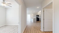 Located at 4039 W Village Pkwy in Ellenwood, GA, this single-floor, 2-bedroom, 2-bathroom residence offers a clean, modern aesthetic with consistent light wood-style flooring and neutral tones throughout. The open-concept kitchen is a standout feature, showcasing granite countertops, a large center island with a single-basin sink, gray shaker-style cabinetry, black appliances, and both track and pendant lighting. The kitchen flows seamlessly into the living area, which benefits from natural light through sliding glass doors that open to an outdoor view, and is outfitted with a ceiling fan. The primary bedroom offers comfortable proportions, a ceiling fan, and access to a spacious walk-in closet with built-in wire shelving. The second bedroom also features a ceiling fan, a standard closet, and a window with outdoor views. Both bathrooms are finished with granite-topped vanities, gray cabinetry, and large-format tile surrounds — one featuring a walk-in shower and the other a full soaking tub. The consistent use of quality materials, modern fixtures, and light, neutral colors creates a cohesive and inviting atmosphere throughout the home.