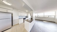 Located at 12-24 Leith Hill Road in Toronto's north end, this well-appointed two-bedroom, one-bathroom unit offers a comfortable and functional layout with an abundance of natural light throughout. The open living area is highlighted by large floor-to-ceiling windows that frame elevated city views, allowing sunlight to pour across the classic parquet flooring. Baseboard heating units run along the window walls, ensuring year-round comfort.

The kitchen is thoughtfully updated with crisp white cabinetry, dark countertops, a light subway tile backsplash, and stainless steel appliances including a refrigerator and dishwasher. Light tile flooring and ample upper and lower cabinet storage make this a highly functional cooking space.

Both bedrooms are generously proportioned, with the primary bedroom offering notable space, parquet floors, a built-in closet, and a bright window overlooking the surrounding cityscape. The second bedroom also benefits from natural light and includes closet access.

The bathroom is clean and well-finished, featuring a tiled tub-shower combination, a white vanity with under-sink storage, a large mirror, and neutral tile flooring. Throughout the unit, a consistent palette of white walls and light tones creates a bright, airy ambiance.