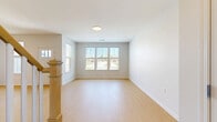 Located at 1657 Fairport Nine Mile Point Road in Penfield, NY, this two-story home offers a well-designed layout across two floors. Light wood flooring flows consistently throughout the space, complementing the neutral gray-toned walls and white trim that give the home a clean, contemporary feel.

The main level features an open kitchen and living area, where the kitchen stands out with navy blue cabinetry, white quartz countertops, stainless steel appliances including a built-in microwave, a subway tile backsplash, and a peninsula with an integrated sink — ideal for both cooking and casual dining. The main floor also includes a dedicated laundry room equipped with a full-size Samsung washer and dryer, upper cabinetry for storage, and an on-site water heater and HVAC system.

The upper floor houses all three bedrooms, including a spacious primary bedroom, and three full bathrooms. Each bathroom is finished with marble-look tile flooring and navy vanities with white countertops and chrome hardware. A walk-in closet with wire shelving and a natural light window adds practical storage. The bedrooms are bright, with multiple windows offering views of the surrounding neighborhood. Three hallways connect the spaces across both levels, ensuring an easy and functional flow throughout the home.