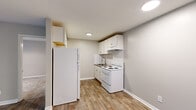 Located at 116 Brock St in Carrollton, GA, this one-bedroom, one-bathroom unit offers a practical and well-organized layout across a single floor. The space is designed for efficient living, with each room serving a clear purpose.

The kitchen is outfitted with white cabinetry, a tile backsplash, laminate wood-look flooring, and white appliances including a full-size refrigerator, electric range, and an under-cabinet range hood. A stainless steel sink with granite-look countertops completes the functional workspace.

The living room features the same wood-look laminate flooring and neutral warm-toned walls, with a window allowing natural light and a wall-mounted HVAC unit for climate control.

The bedroom is carpeted for added comfort, features a ceiling fan with integrated lighting, and includes a closet. A window provides natural light and a view of the surrounding greenery, contributing to a calm atmosphere.

The bathroom includes a full-size soaking tub with an overhead shower, finished in clean white surroundings.

Throughout the unit, neutral gray and beige tones create a cohesive, understated aesthetic. Clean white trim and recessed lighting add polish to each room, making this a straightforward and functional living space.