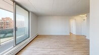 Located at 1200 Talwood Dr in Peterborough, Ontario, this well-appointed one-bedroom, one-bathroom unit offers a clean, modern aesthetic throughout its efficiently designed layout. Light-toned hardwood-style flooring runs continuously across all rooms, lending a cohesive and airy feel to the entire space.

The living room is the standout area of the unit, featuring a large floor-to-ceiling sliding window that draws in abundant natural light and provides open outdoor views, creating a bright and inviting atmosphere. Baseboard heating runs along the perimeter, and crisp white walls complement the light flooring throughout.

The kitchen is thoughtfully designed with white cabinetry, classic white subway tile backsplash, and stainless steel appliances including a range and microwave. It opens conveniently toward the living area, allowing for a functional and connected flow between spaces.

The bedroom is a comfortable, well-sized room featuring a closet and the same warm flooring found throughout. Its clean white walls and simple layout make it a versatile and restful retreat.

The bathroom is finished with full white subway tile surrounding the soaker tub and shower combination, paired with chrome fixtures for a polished, timeless look.

A hallway connects all areas of the unit seamlessly. The overall ambiance is clean, bright, and move-in ready, reflecting a modern and practical residential design.