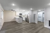 Located at 902 W Remington Dr in Sunnyvale, CA, this 2-bedroom, 1-bathroom single-floor home offers a clean, modern aesthetic throughout. Light gray luxury vinyl plank flooring runs seamlessly across all rooms, complementing the bright white walls and creating a cohesive, contemporary feel.

The kitchen is a standout feature, boasting white shaker cabinets, white quartz countertops, a breakfast bar peninsula, a skylight, and a full suite of stainless steel appliances including a refrigerator, dishwasher, range, and microwave. Stylish pendant lights add a finishing touch. The kitchen flows into a dedicated dining area and an open living room anchored by a classic white brick fireplace, with large windows providing ample natural light.

Both bedrooms are well-proportioned and finished with the same light flooring and neutral walls. The primary bedroom features recessed lighting, while the second bedroom includes a window with blinds. Three closets provide generous storage, including one with mirrored sliding doors. The full bathroom is neatly appointed with a white vanity, combination tub and shower, and matching flooring. A dedicated laundry area and a connecting hallway complete the efficient, well-organized floor plan.