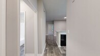 Located in Atlanta's 30315 neighborhood, this single-story, 2-bedroom, 2-bathroom home offers a practical and comfortable layout across a well-utilized footprint. The open-concept living room is a standout, featuring rich wood-look plank flooring, a ceiling fan with light fixture, and a bank of windows that flood the space with natural light while offering views of the surrounding greenery. The kitchen is equipped with white cabinetry, light countertops, a black electric range with an overhead vent, a sink, and a kitchen island, all complemented by the same durable wood-look flooring. Both bedrooms are generously sized, carpeted for comfort, and receive ample natural light through large windows with blinds. The spacious primary bedroom includes its own ceiling fan. Each bedroom is served by a full bathroom featuring a soaking tub and shower combination. The home also includes two closets with wire shelving, a dedicated laundry area with utility hookups, and two hallways that connect the layout efficiently. Neutral warm-gray walls throughout create a cohesive and move-in ready aesthetic.
