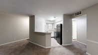 Located at 630 Bell Road in Nashville, TN, this single-floor, three-bedroom, two-bathroom home offers a well-organized layout with comfortable living spaces throughout. The living room is a standout feature, anchored by a classic white-framed fireplace and carpeted flooring, with natural light filtering in through a window — creating a warm and inviting atmosphere. Adjacent to the living area, the kitchen is designed for functionality, featuring white cabinetry, light wood-style flooring, black appliances including a refrigerator, dishwasher, and range, along with a sink beneath a window. A peninsula breakfast bar provides a convenient transition between the kitchen and living spaces. A carpeted hallway connects the three bedrooms, each finished with neutral tones and plush carpet. The generously sized primary bedroom includes a walk-in closet equipped with built-in shelving and dual hanging rods for ample organization. The bathrooms feature wood-look tile flooring, with at least one offering a glass-enclosed shower stall. A standout feature of this home is the covered outdoor deck, which overlooks a lush, densely wooded backdrop — offering a tranquil outdoor retreat with excellent privacy and natural scenery.