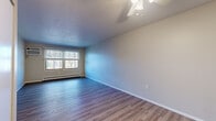 Located at 5325 13th St SW in Canton, Ohio, this two-bedroom, one-bathroom unit offers a practical and well-maintained single-floor layout. Wood-look vinyl flooring runs consistently throughout the entire space, giving it a cohesive and clean aesthetic.

The living room serves as the central gathering area, featuring a ceiling fan with light fixture, a textured ceiling, and windows that invite natural light while offering views of the surrounding tree line. An adjacent galley-style kitchen is efficiently designed with white cabinetry, light countertops, a stainless steel double sink, an electric range, and a full-size refrigerator — all finished with a drop ceiling and recessed lighting.

Both bedrooms are well-proportioned, with the primary bedroom offering ample space, a ceiling fan, and good natural light. The second bedroom includes a closet and a window with outdoor views, complemented by baseboard heating. A wall-mounted air conditioning unit is also present.

The bathroom is outfitted with a full tub and shower combination, grab bars for added safety, a white vanity, and wood-look flooring that mirrors the rest of the unit. A hallway connects the rooms efficiently, completing this compact yet functional layout.